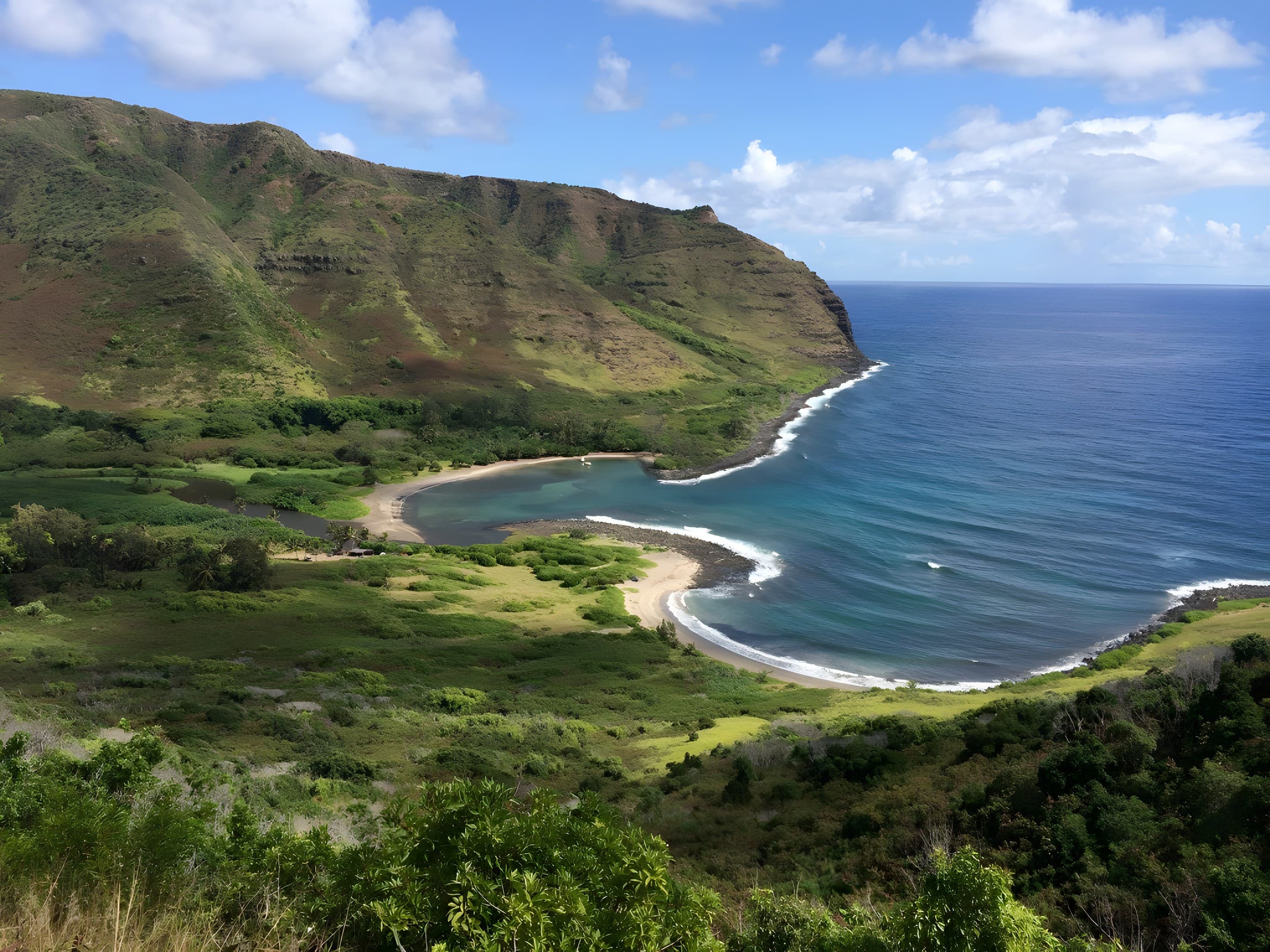 A sweeping Molokaʻi bay framed by green sea cliffs and a crescent beach