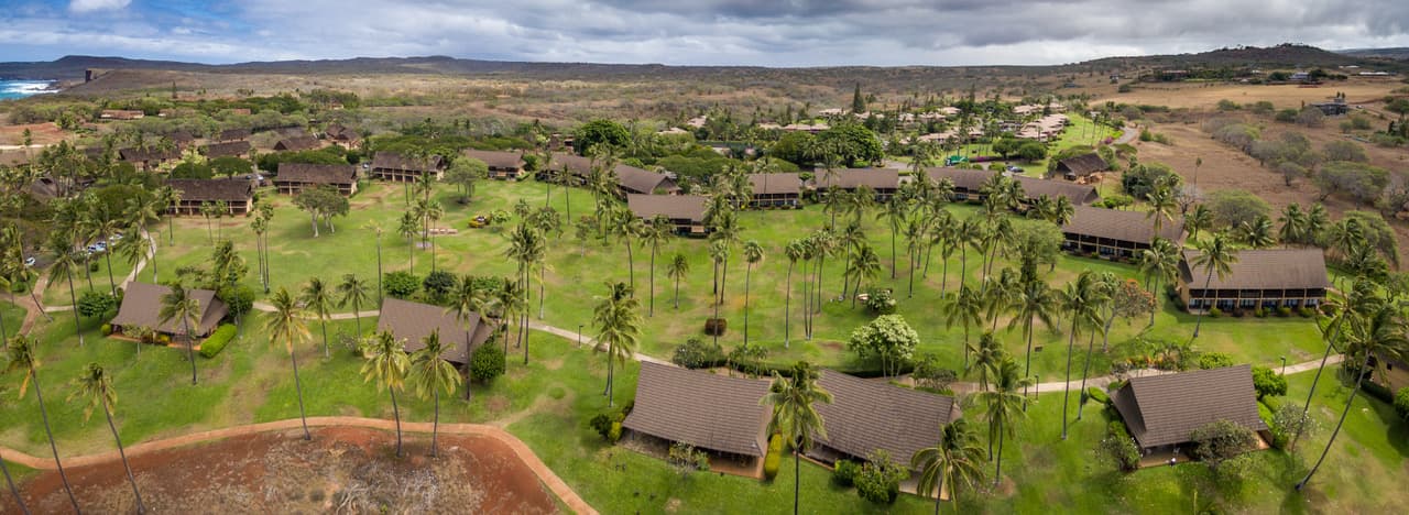 Wide panorama across the resort's lawns and scattered cedar buildings toward the dry west-end hills